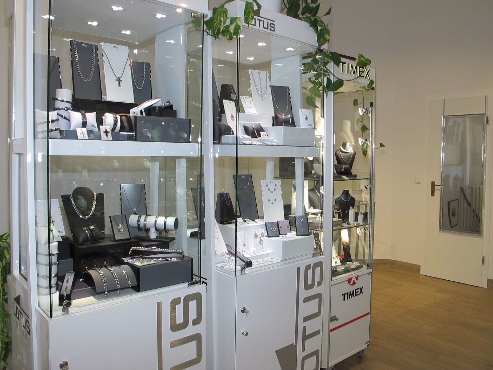 Nahaufnahme der beleuchteten Uhrenvitrinen mit Modellen von Lotus und Timex